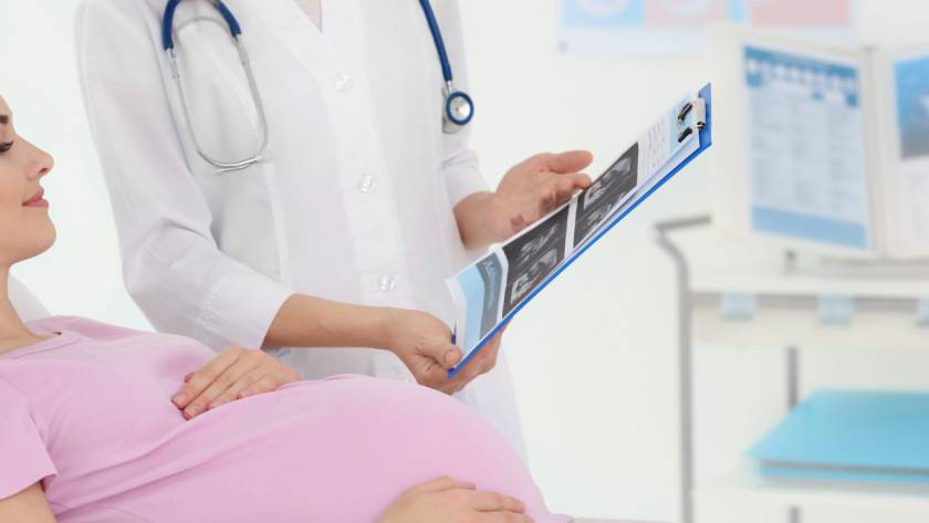 A doctor showing an ultrasound to a pregnant person