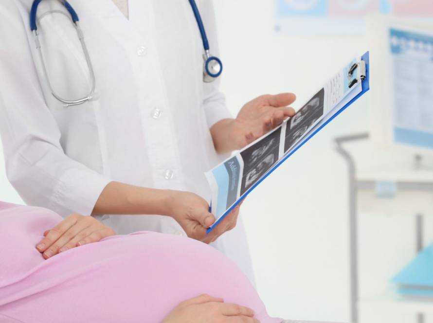 A doctor showing an ultrasound to a pregnant person